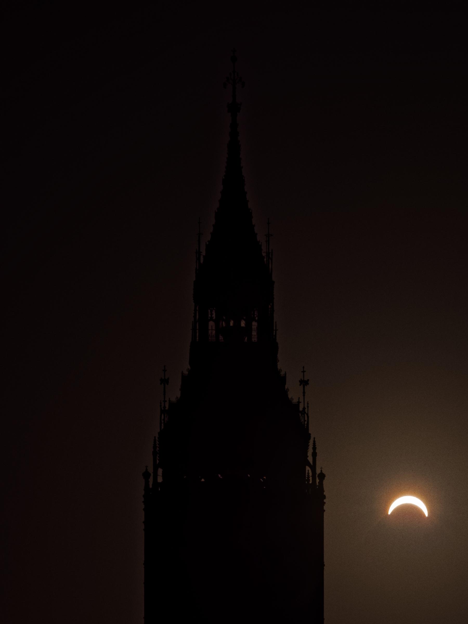 A photograph of the solar eclipse of 12 August 2026 at the point of maximum partial eclipse. The eclipsed sun can be seen towards the bottom right of the frame whilst the silhouette of the top of Big Ben (from the clock upwards) dominates the centre of the frame.