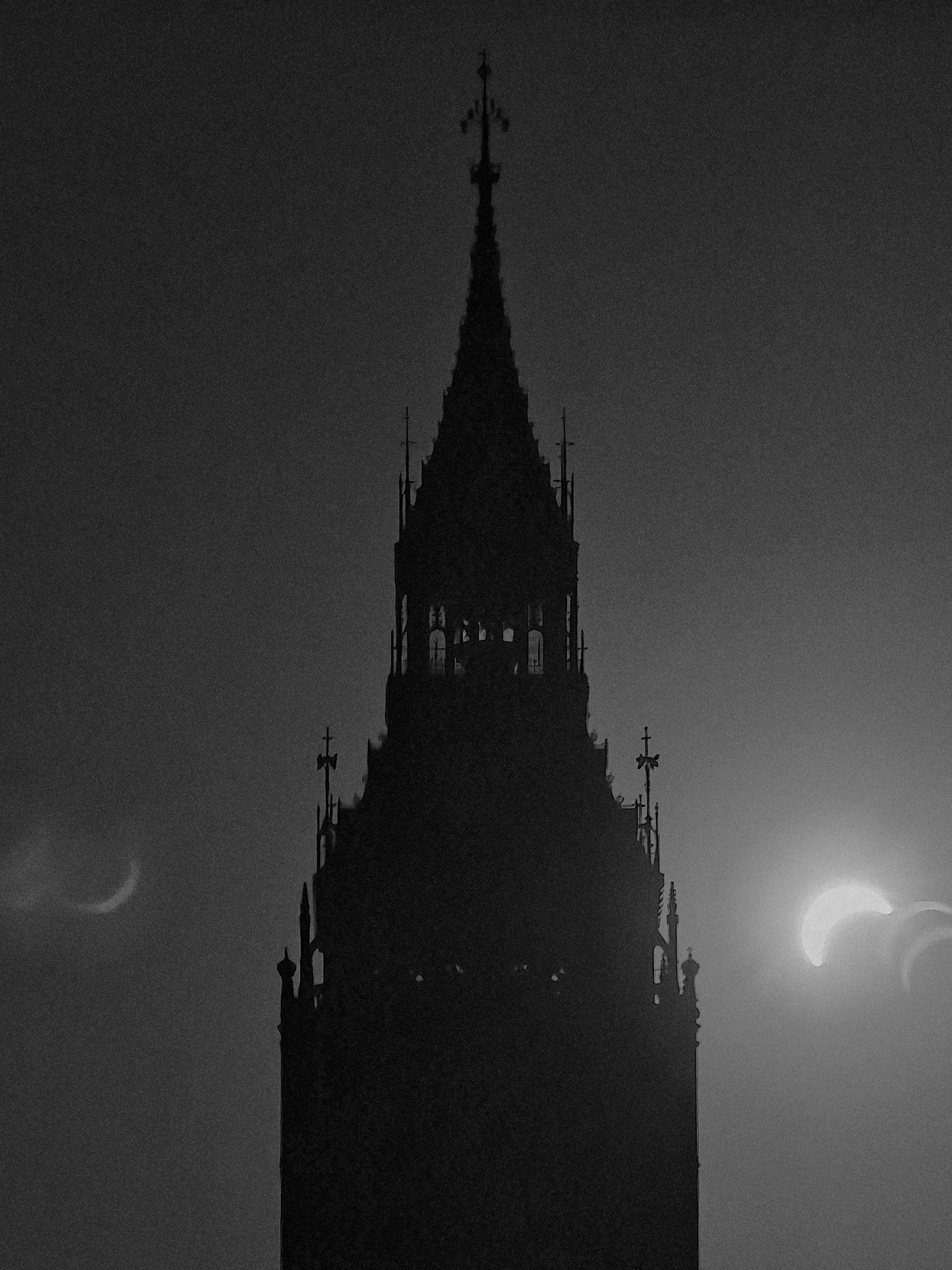 A black and white photograph with Elizabeth Tower silhouetted against a darkened sky as the partial eclipse in London neared the point of maximum partial eclipse.