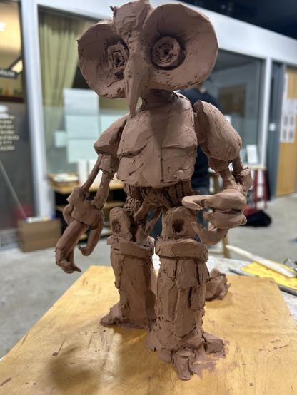 An in progress sculpture of a robotic owl lady, mostly from the front