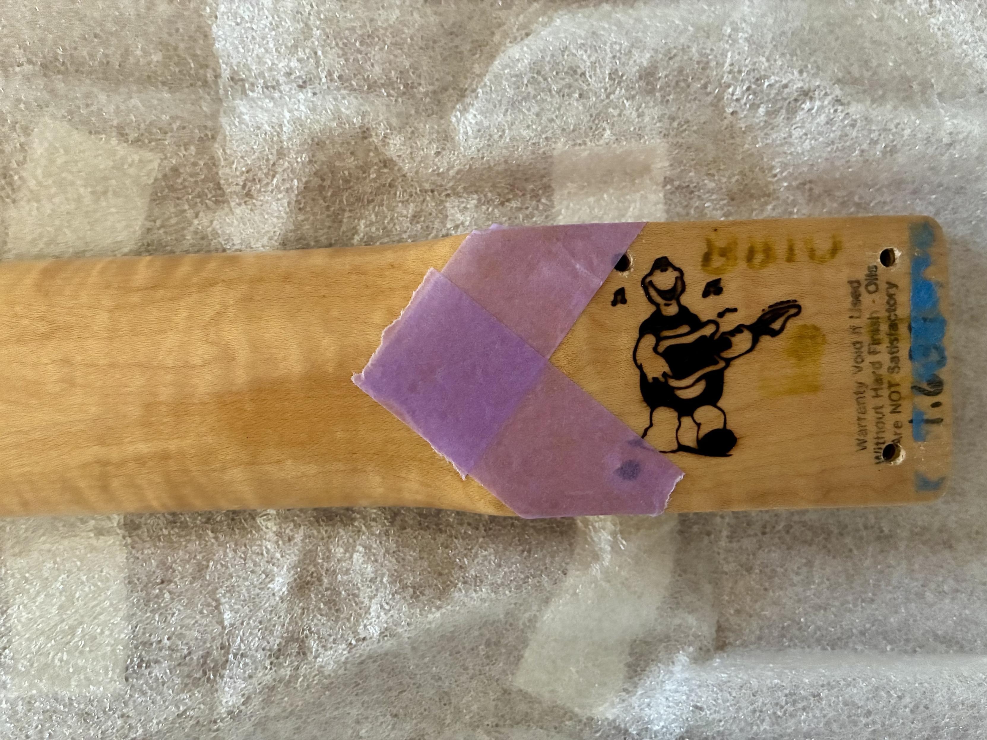 Close up of masking tape affixed to neck at bolt-on body end