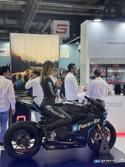 Blonde haired woman in very tight Lycra sat on a motorbike