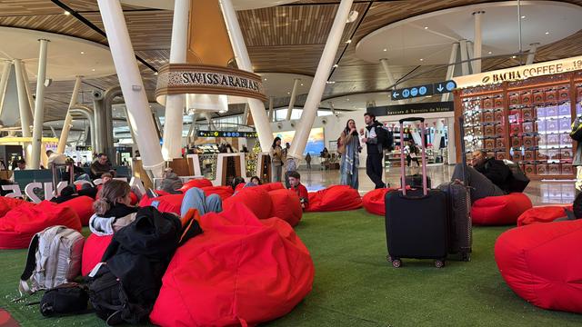 Airport lounge area with people relaxing on red beanbags