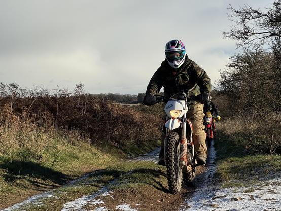 Woman on her motorbike, stood up. 
