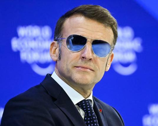 Emmanuel Macron on stage at the WEF wearing silvered aviator glasses. 