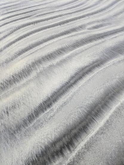 Silver and grey sand in a wavy corrugated pattern.