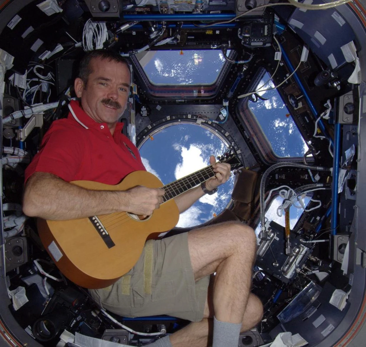 Chris Hadfield with his guitar in the ISS cupola.