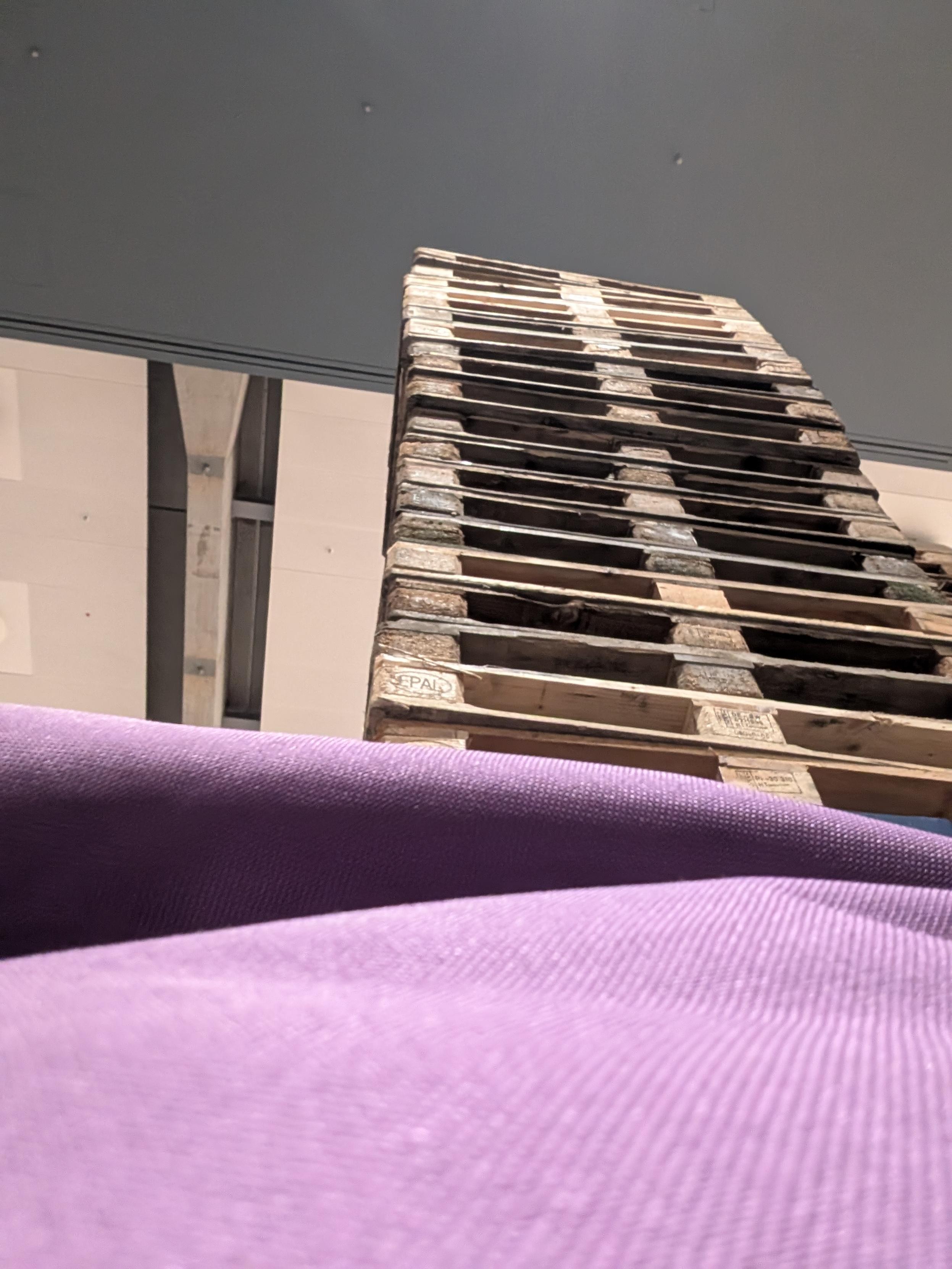 Ein stapel paletten mit einem sitzsack darunter