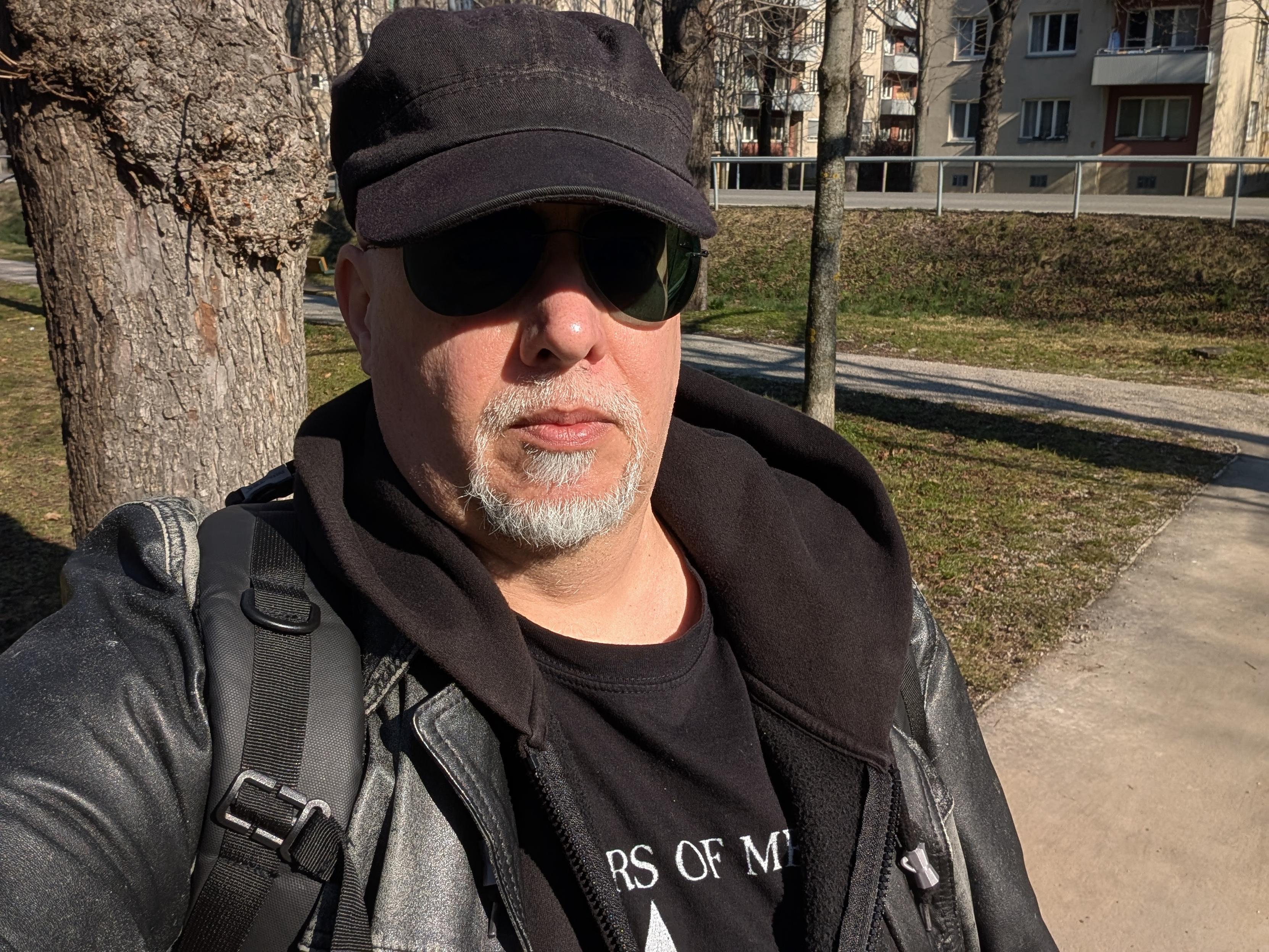 Leyrer wearing black hat, black sunnglasses, black leather coat, black hoodie, black sister of mercy t-shirt