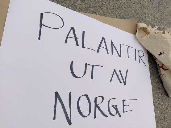 En plakat for en markering. På plakaten står det "Palantir ut av Norge"