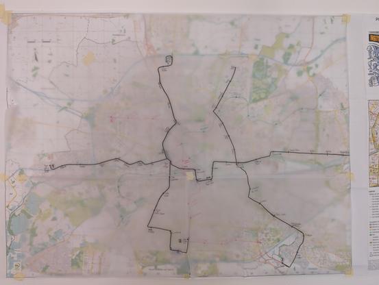 Plan de la ville de Rennes avec des calques par dessus sur lesquels sont dessinés les tracés de trois lignes de tram au feutre noir.