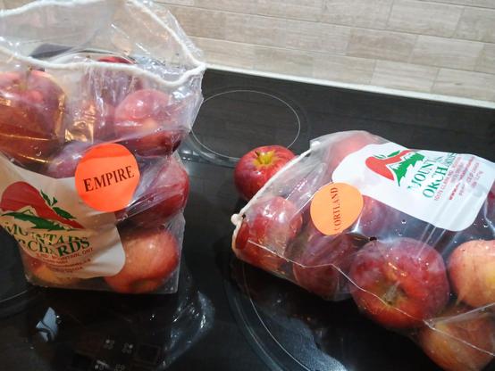 Two bags of apples each holding maybe 12-15 apples.