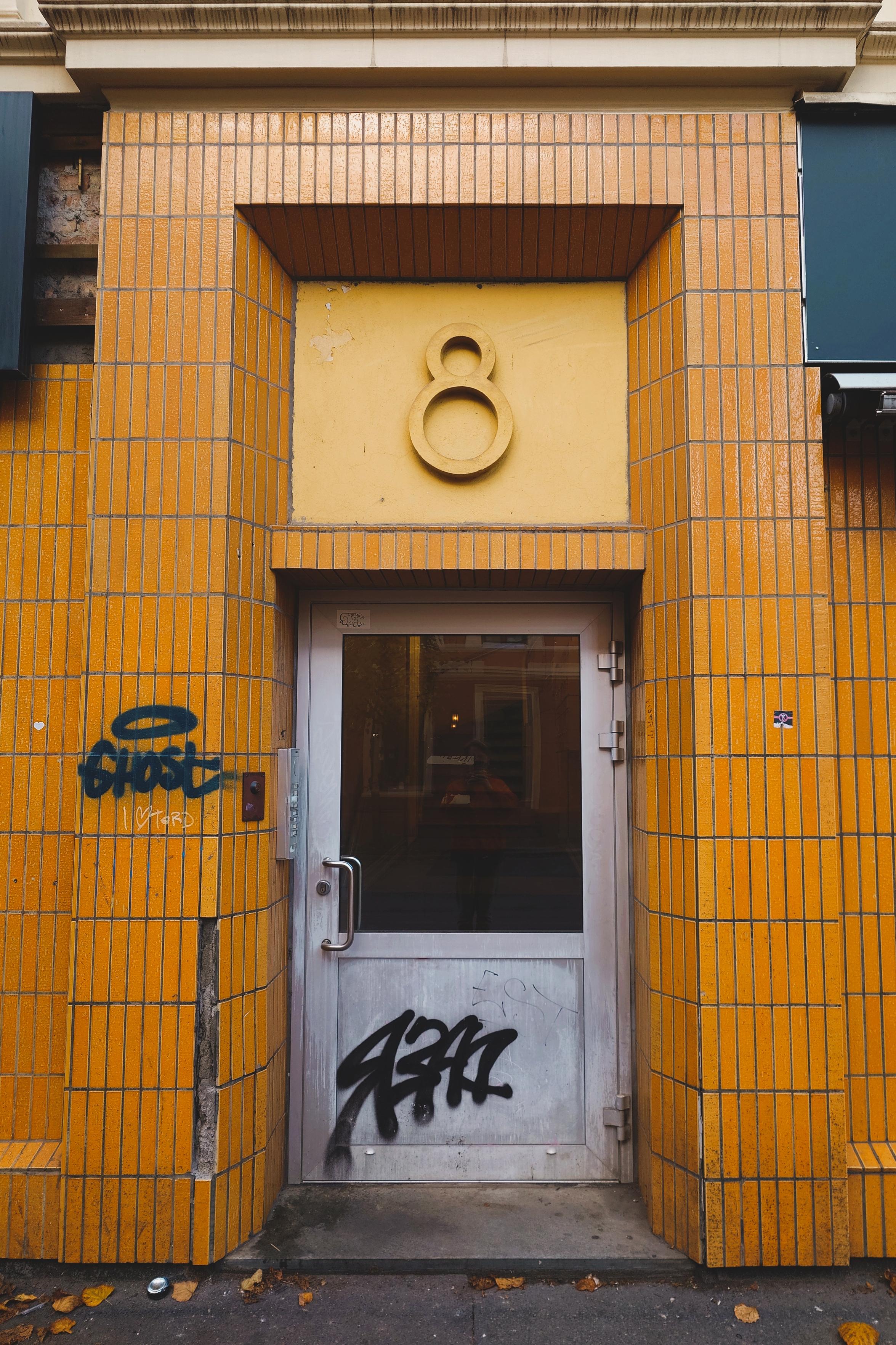 An entrance to an apartment block with a stylised number 8 over the door.