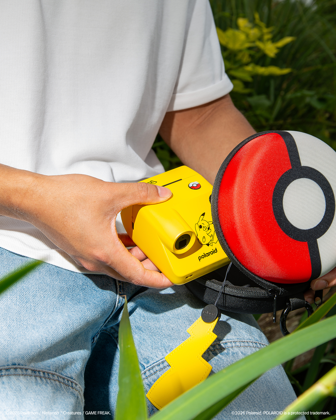 A Pikachu themed pokemon camera. It is bright yellow has a tail handstrap and the shutter button is a pokeball.