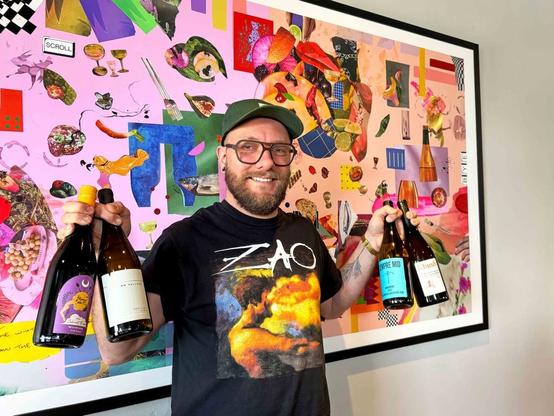 Wes Klassen holding bottles of wine.