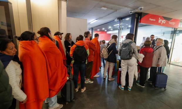 Un grupo de personas espera a la salida de los trenes en la estación de Delicias de Zaragoza para volver a sus casas este martes tras el apagón. (EFE/ Javier Belver)