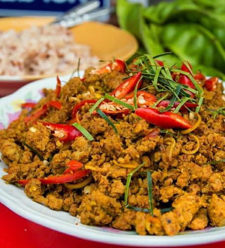 A photo of a brown minced pork curry with sliced red chilis on top