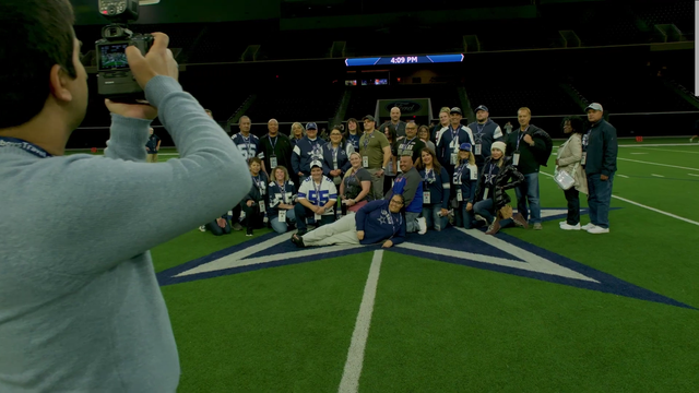 Cowboys' fans getting their photo taken on the 50-yard line at the Dallas Cowboys' Practice Facility at The Star in Frisco, TX. This is the same tour that Dalton Schultz is referencing with fans banging on the window of the training room while the players are trying to get their workouts in. Truly a zoo-like, distraction-heavy environment.