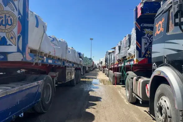 Trucks line up at the Rafah crossing between Egypt and the Gaza Strip [Mohamed Arafat/AP]