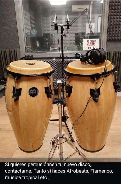 Estudio de grabación con micrófono, cascos e instrumentos de percusión.