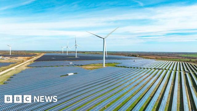 Solar panels and wind turbines shown in a landscape