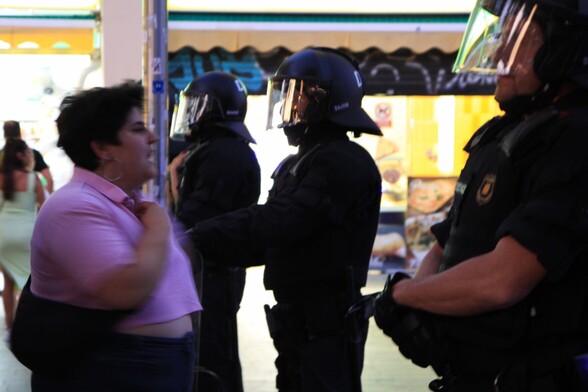 Una mujer joven, gorda y muy estilosa, con el pelo corto, polo rosa muy cortito y bolso colgado en bandolera, increpa desde primerísima fila al cordón de Mossos d'Esquadra que impide avanzar la concentración antifascista