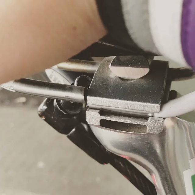A close up of a bike saddle, with the mounting bracket broken where it connects to the seat post, being wiggled up and down by a hand.
