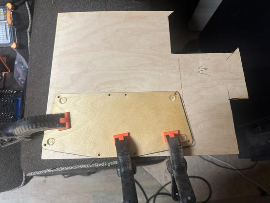 A small wooden board clamped onto a larger board.