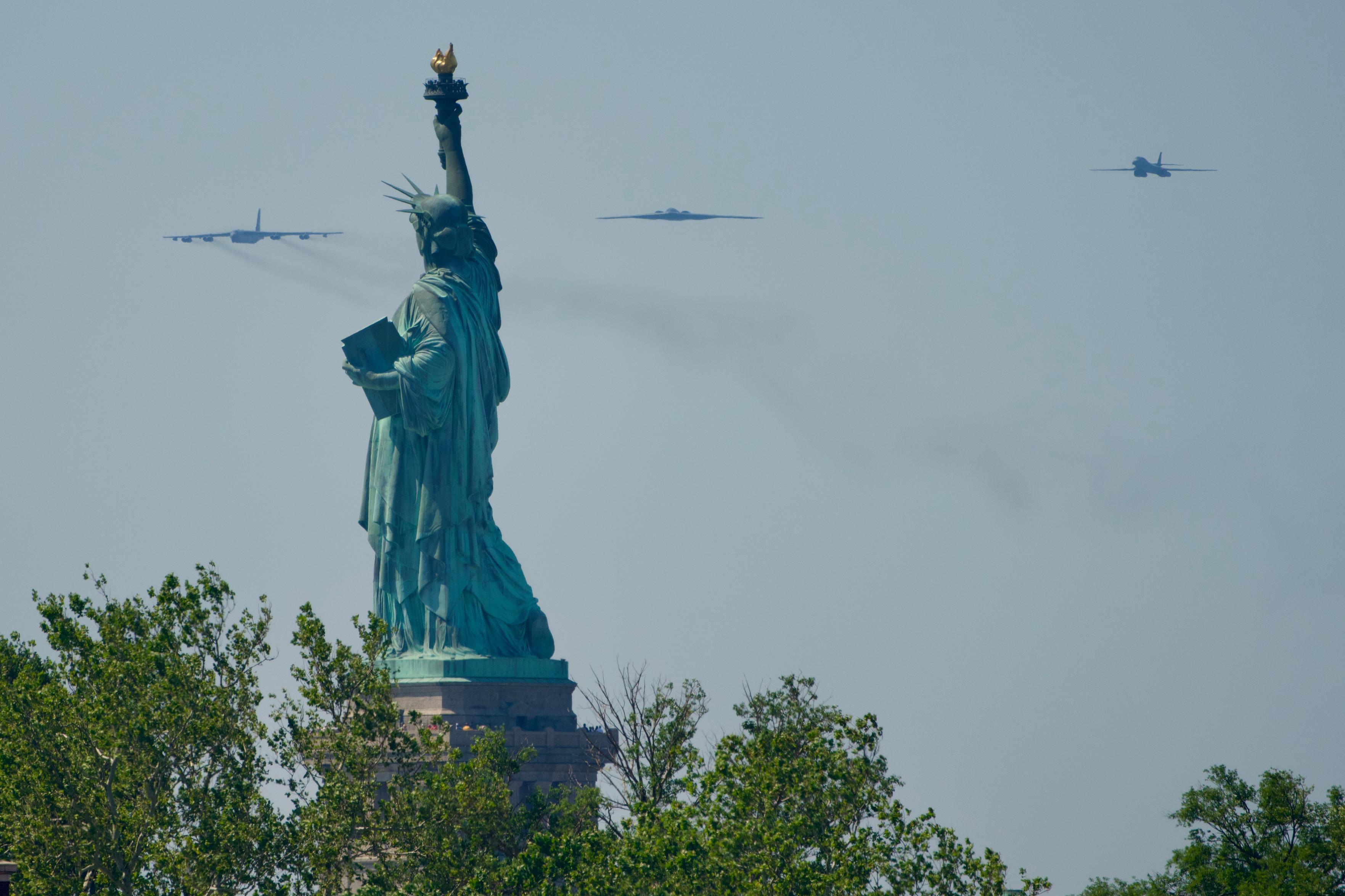 B-52, B-2, and B-1 bombers flying north above the Statue of Liberty.