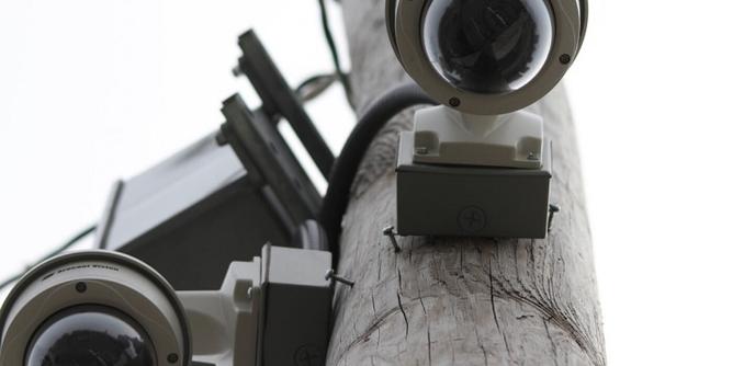 Two surveillance cameras mounted to a pole.