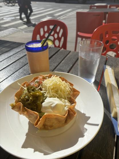 Taco bowl and frozen margarita, pictured outside at a restaurant in the city.