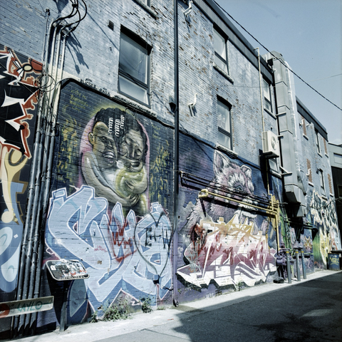 A pale blue hue covers graffiti clad alley walls.