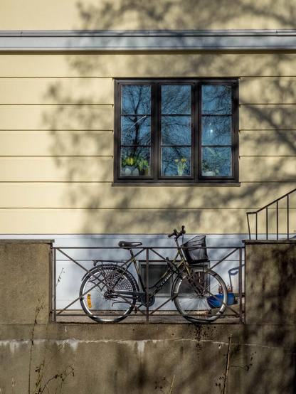 A bicycle against a yellow wall.