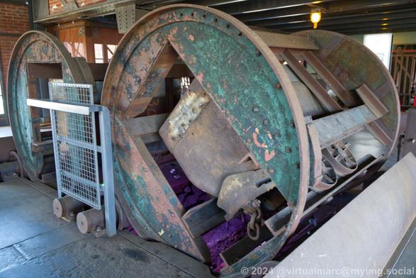 A photo of a machinery where a minecart can drive in and is turned upside down to empty it.