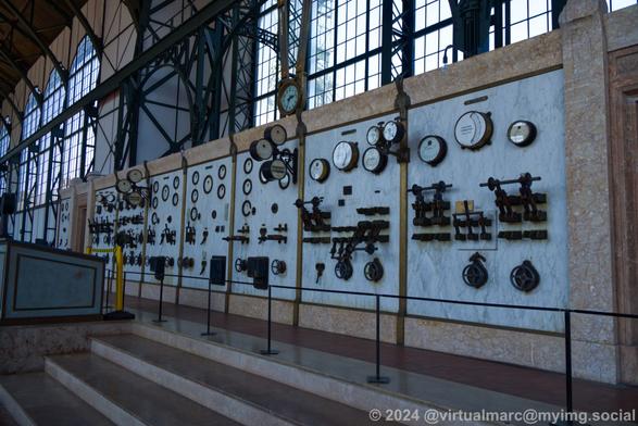 A wall inside the machine hall made out of marmor with many scales, buttons and levers.