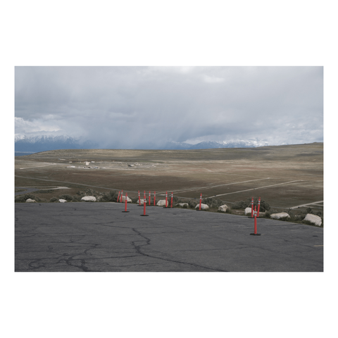 Looking out from a parking lot with a group of safety cones that's high above the valley below