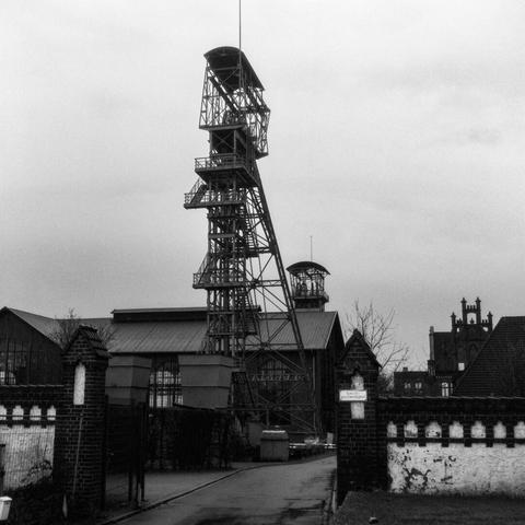 Black and white photo of the headframes of shafts II and IV and the engine hall at Zollern colliery in Dortmund.