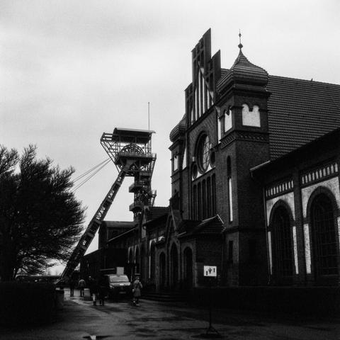 Black and white photo of the headframe at shaft II and part of the wage hall of Zollern colliery in Dortmund.