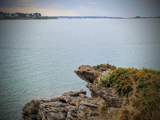 La côte avec l'océan et des rochers. Le ciel est orageux mais encore beau.
