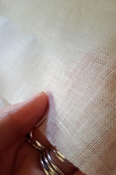 More fabric, manipulated in such a way that the raking sideways light plays across the surface of it. It is very very smooth and has a slight shimmer and shine to it, like a bit of snow with sunlight hitting it. Quite lovely. It would feel light, weightless, soft and smooth to the skin, though with fingertips you could feel the slight texture of the latticework of the woven fibres.