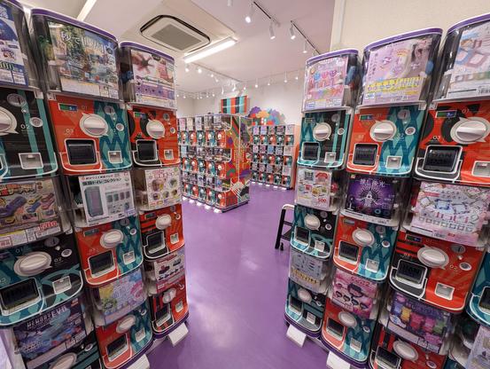 In a room with a purple floor, countless small vending machines are stacked head-high in rows, selling small figurines and other items. They're conceptually similar to gumball machines.
