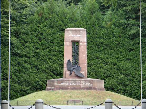 the entire  monument,  standing on a mound, green trees behind it