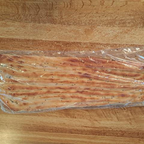 Large flat bread in plastic on a counter