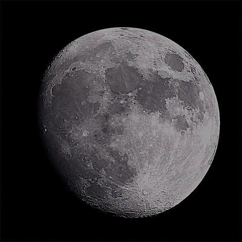 The Moon at waxing gibbous phase on a dark background.