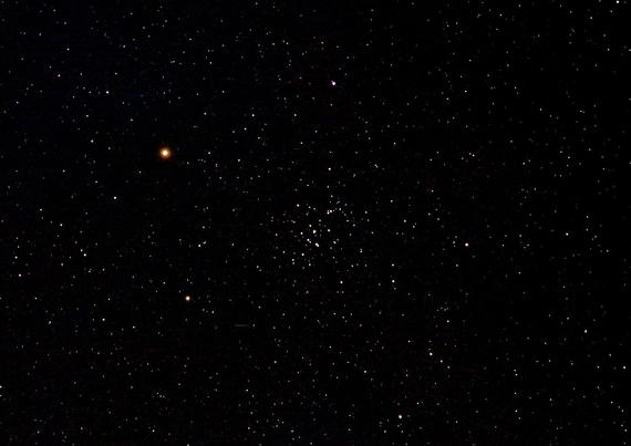 The Beehive cluster of stars at centre. Bright orange planet Mars above left of centre. Many other star dots on a dark background.