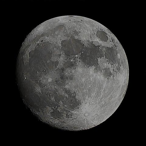 The Moon at waxing gibbous phase on a dark background.