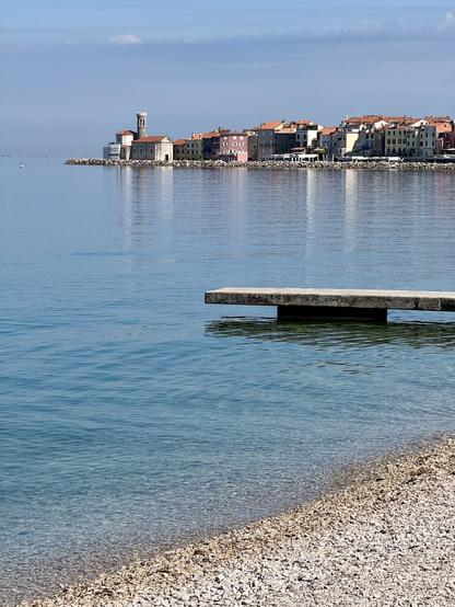 Beach & inviting water with end of small bathing/ fishing pier & old town in distance