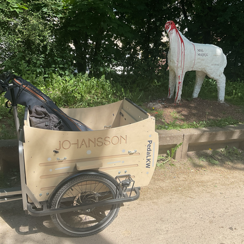 zwei fotos von eselskunstwerken … einmal auf stelzen … einmal ebenerdig mit abgetrenntem kopf … davor jeweils mein lastenrad