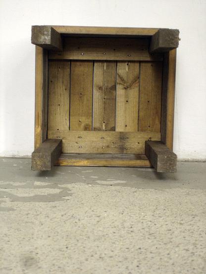 view from below of the wooden stool made of found, weathered wood and nails.