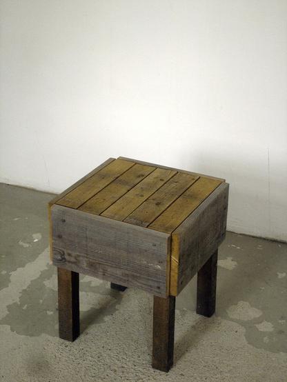 perspective view of the wooden stool made of found, weathered wood and nails.