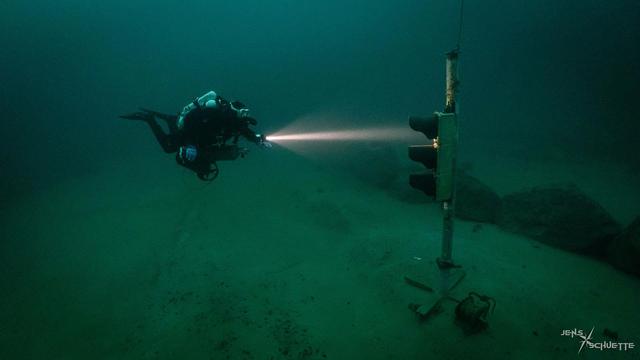 Diver waiting in front of a traffic light that does not turn green.